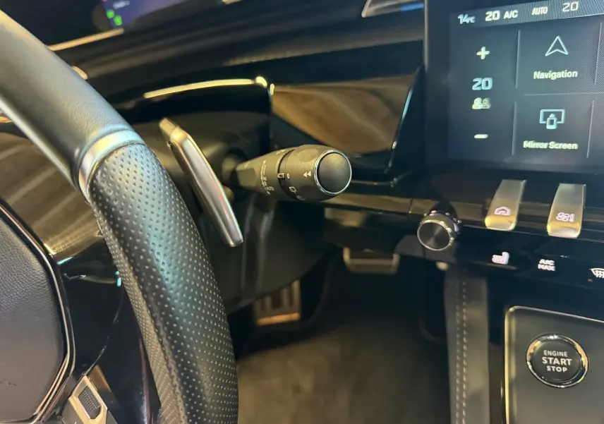 Vue rapprochée de l’intérieur côté conducteur du Peugeot 508 SW noir, volant cuir perforé et console tactile avec boutons chromés.