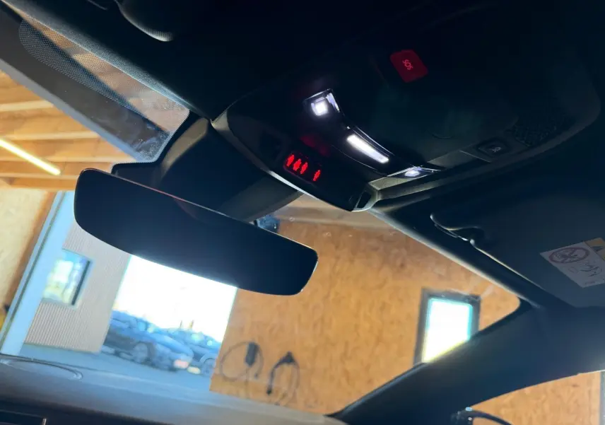 Vue intérieure du rétroviseur central et plafonnier avec éclairage LED dans un Peugeot 508 SW noir 2024.