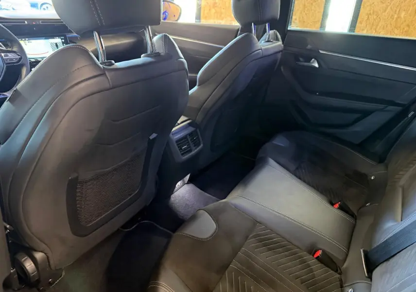 Vue intérieure arrière côté droit de la Peugeot 508 SW 2024, sièges en cuir noir avec surpiqûres et finitions élégantes.