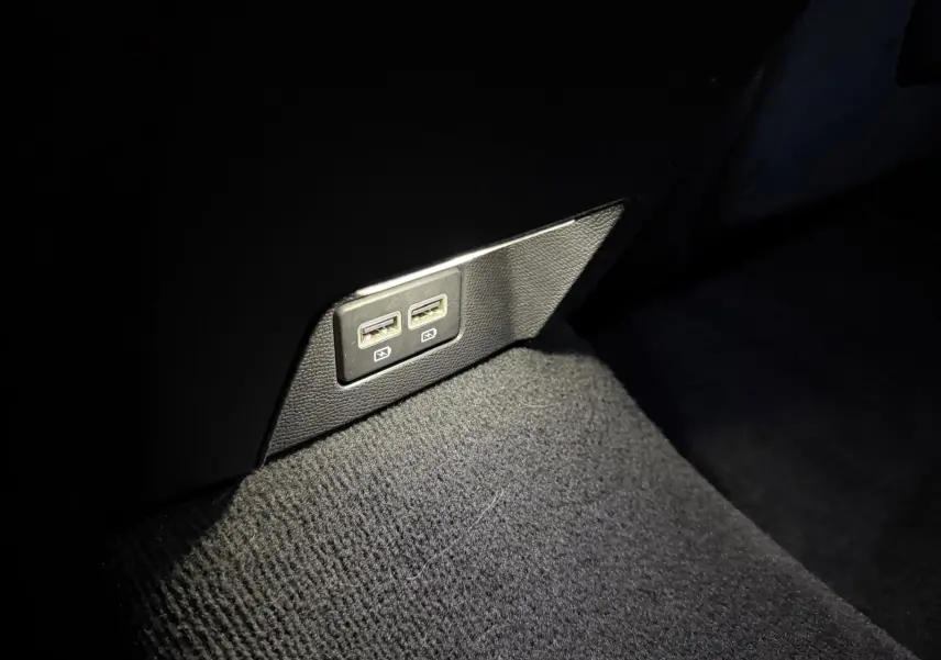 Prise USB double arrière sur tapis noir dans l’habitacle d’une Peugeot 508 SW 2024 finition GT.