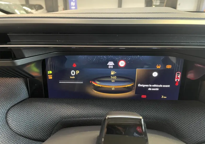 Vue rapprochée du tableau de bord numérique du Citroën C5 Aircross 2026 avec affichage des alertes et jauge d’essence.