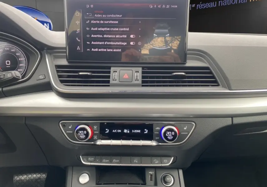 Vue intérieure du tableau de bord de l'Audi Q5 35 TDI noir, avec écran tactile central et commandes climatisation 3 zones.