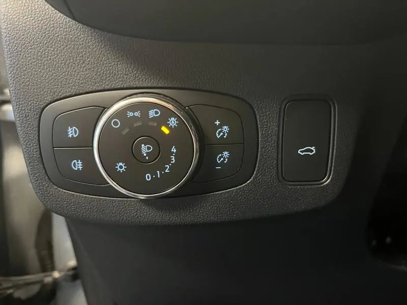 Gros plan sur les commandes d'éclairage et le bouton de hayon électrique du Ford Puma gris Solar Métallisée 2021.