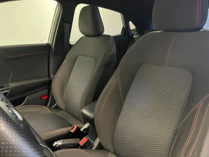 Gros plan sur les sièges avant noirs avec surpiqûres rouges de la Ford Puma 2021, côté conducteur et passager.