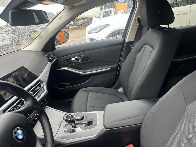 Intérieur avant droit de BMW Série 3 316dA 2021 avec sièges sport en tissu noir et console centrale moderne.