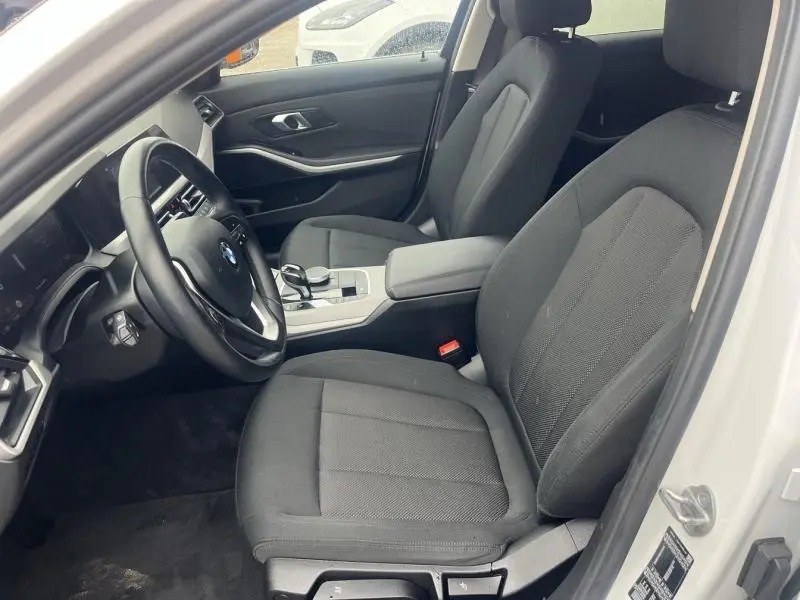 Intérieur avant droit d'une BMW Série 3 316dA 2021 avec sièges tissu noir et accoudoir central ouvert.