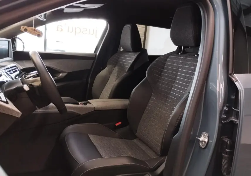 Vue intérieure côté gauche du Peugeot 5008 2025 bleu Ingaro, sièges tissu et cuir avec planche de bord moderne.