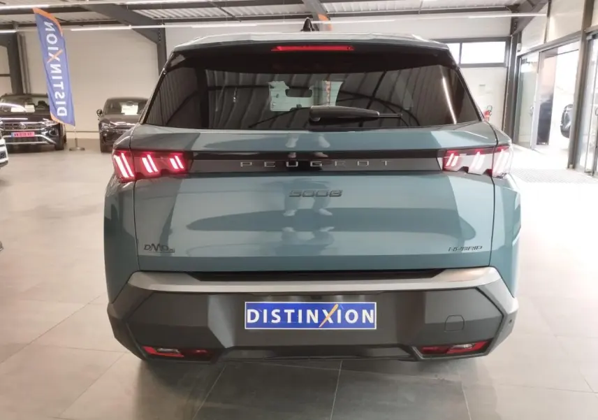 Vue arrière d'un Peugeot 5008 Hybrid bleu Ingaro avec feux arrière LED à 3 griffes et bandeau noir laqué.