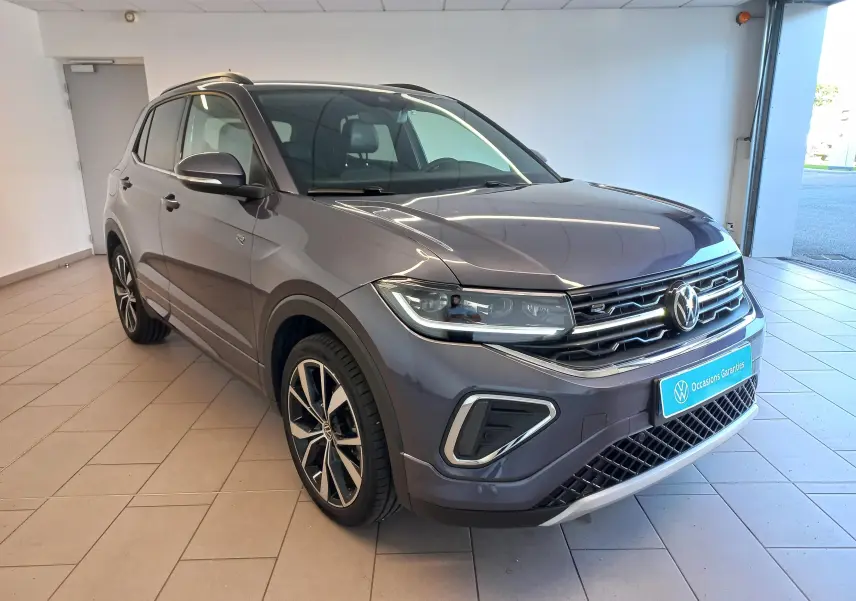 Volkswagen T-Cross 2025 gris cendré en 3/4 avant droit, avec jantes alliage 18 pouces et finition R-Line Edition.