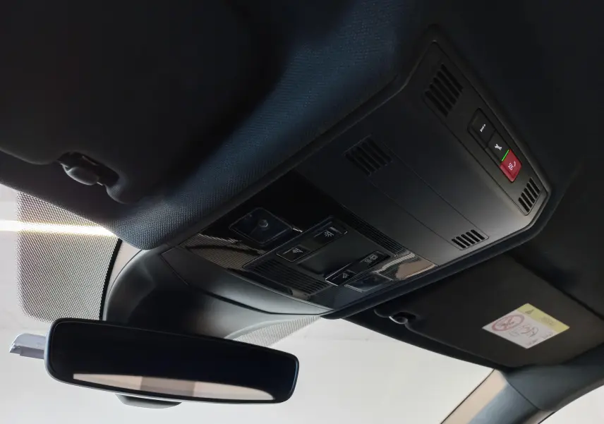 Vue intérieure du plafonnier noir avec commandes d’éclairage et rétroviseur dans un Volkswagen T-Cross gris cendré 2025.
