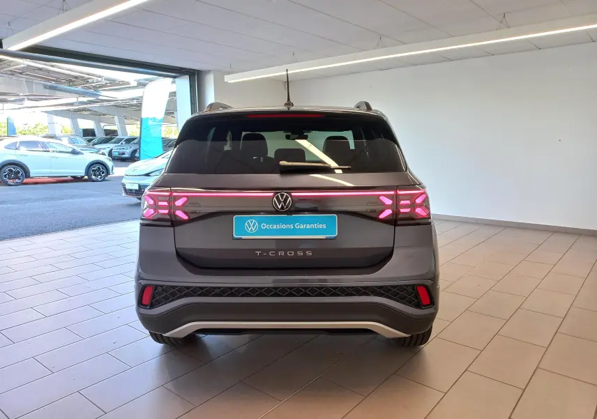 Vue arrière d'un Volkswagen T-Cross gris cendré 2025 avec feux arrière LED distinctifs et plaque "Occasions Garantis".