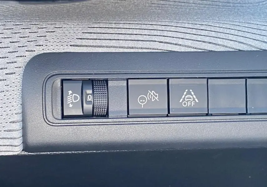 Gros plan sur les commandes d'assistance à la conduite sur la planche de bord grise du Citroën C3 Aircross 2026.