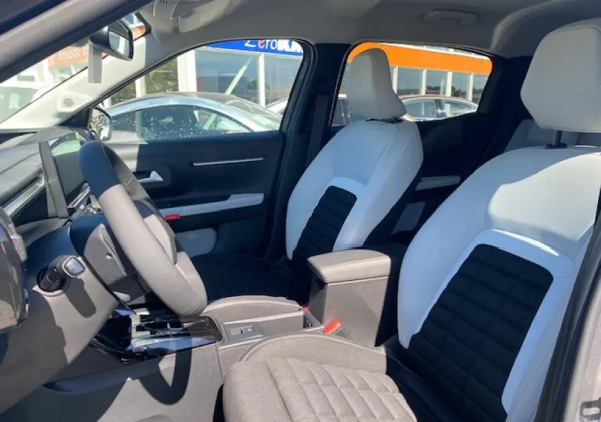 Vue intérieure avant droite du Citroën C3 Aircross 2026, sièges bicolores noir et blanc avec console centrale noire.