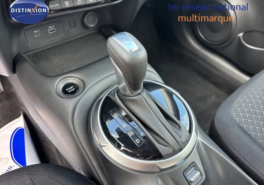Gros plan sur le levier de vitesses automatique et bouton start/stop dans l’habitacle noir du Nissan Juke Hybrid 2024.