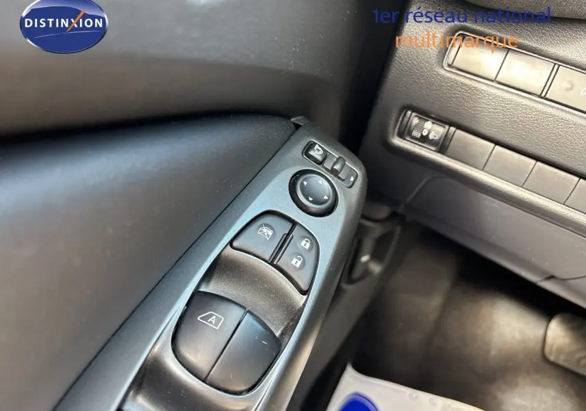 Gros plan sur les commandes de vitres et rétroviseurs côté gauche du Nissan Juke Hybrid gris squale métal 2024.