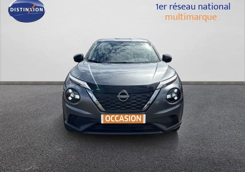 Vue frontale d'un Nissan Juke Hybrid 143ch Business Edition gris squale métal avec calandre noire et phares ronds LED.
