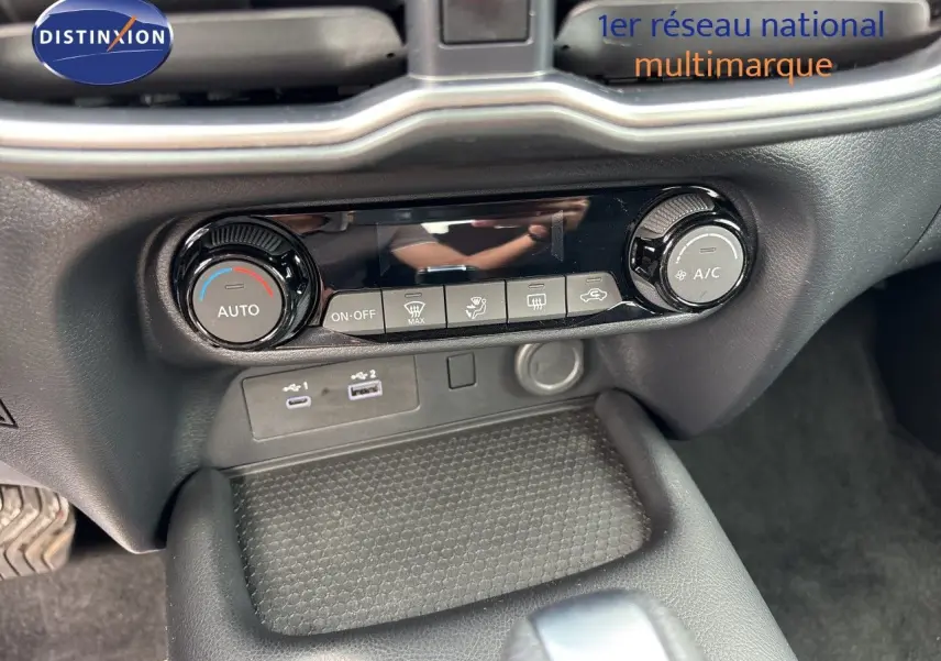 Vue rapprochée de la console arrière entre les sièges noirs en tissu du Nissan Juke gris Squale Metal 2024.