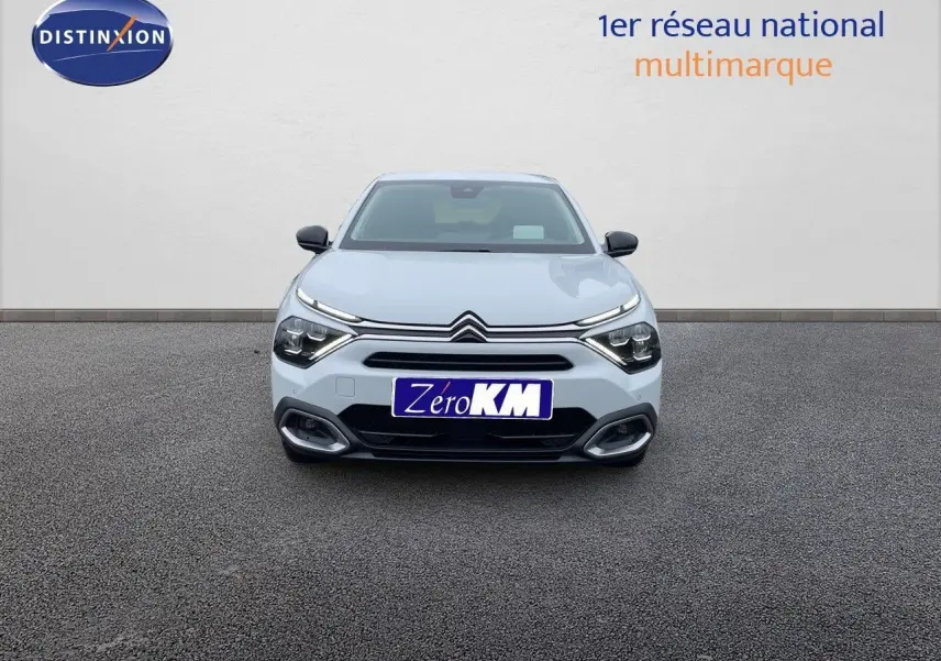 Vue frontale d'une Citroën C4 blanche métal 2024 avec phares LED et calandre distinctive sur fond neutre.
