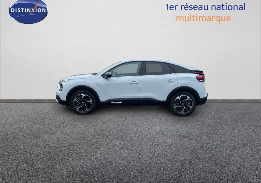 Profil côté gauche d'une Citroën C4 blanc métal 2024 avec jantes noires et détails noirs contrastants.
