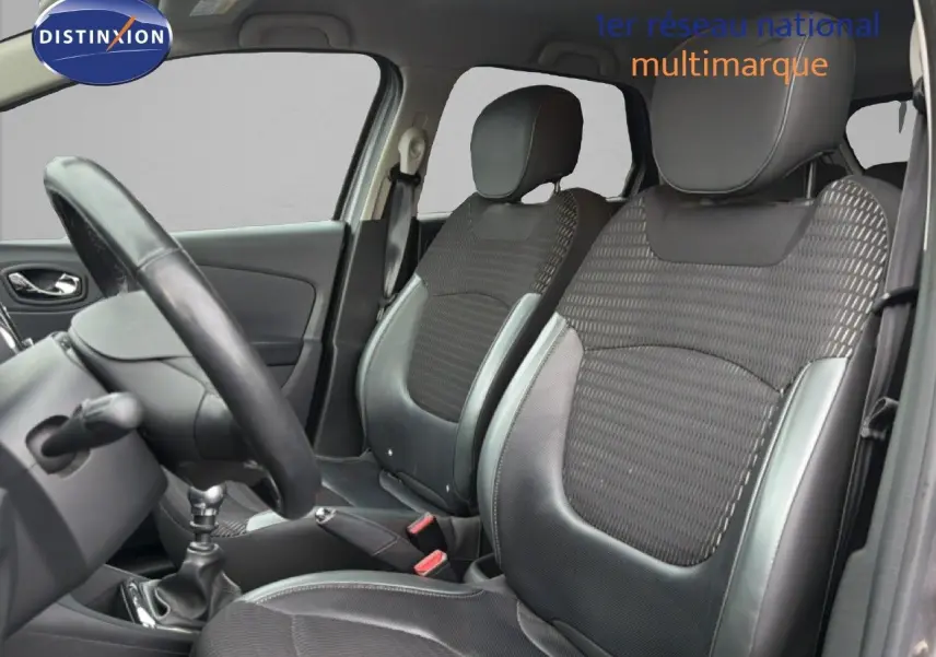 Vue intérieure côté gauche montrant les sièges avant en tissu et cuir gris du Renault Captur 2016 avec volant et levier de vitesse.