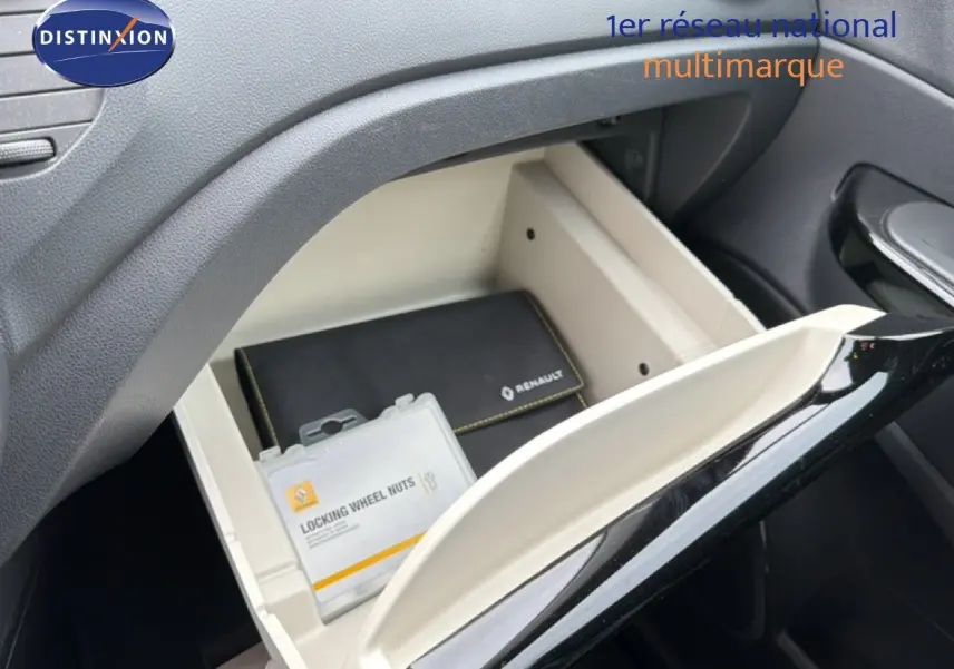 Gant de boîte à gants ouvert intérieur beige et noir avec pochette Renault et boîte d'écrous antivol visible.