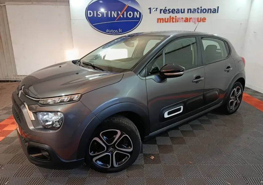 Citroën C3 BlueHDi 100 BVM Plus gris foncé vue 3/4 avant droit avec protections latérales et jantes spécifiques.