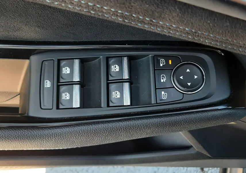 Gros plan sur les commandes de lève-vitres et rétroviseurs côté gauche du Renault Austral 2025, intérieur noir.