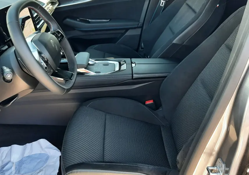 Vue intérieure côté conducteur du Renault Austral 2025 gris schiste, sièges noirs et console centrale moderne avec volant multifonction.