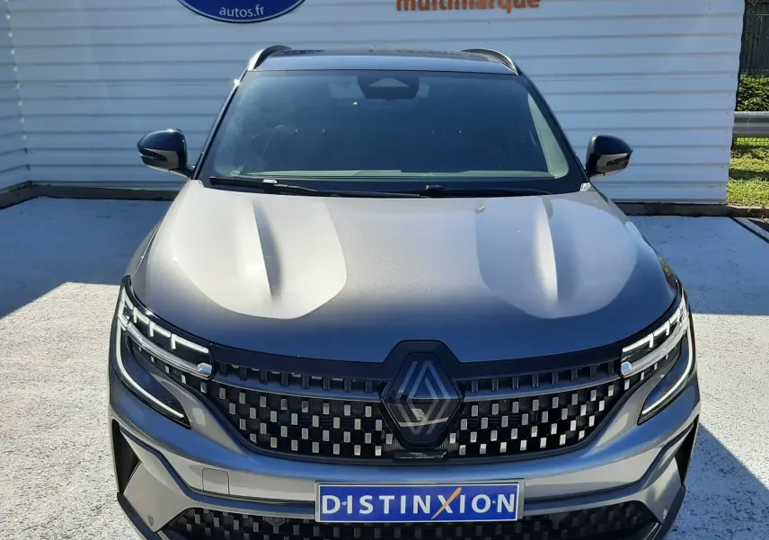Vue de face du Renault Austral E-Tech Full Hybrid gris schiste avec toit noir, mettant en valeur sa calandre distinctive et ses phares LED.