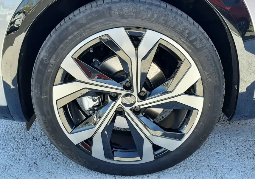 Gros plan sur la jante alliage bicolore au design géométrique du Renault Austral gris schiste avec toit noir.