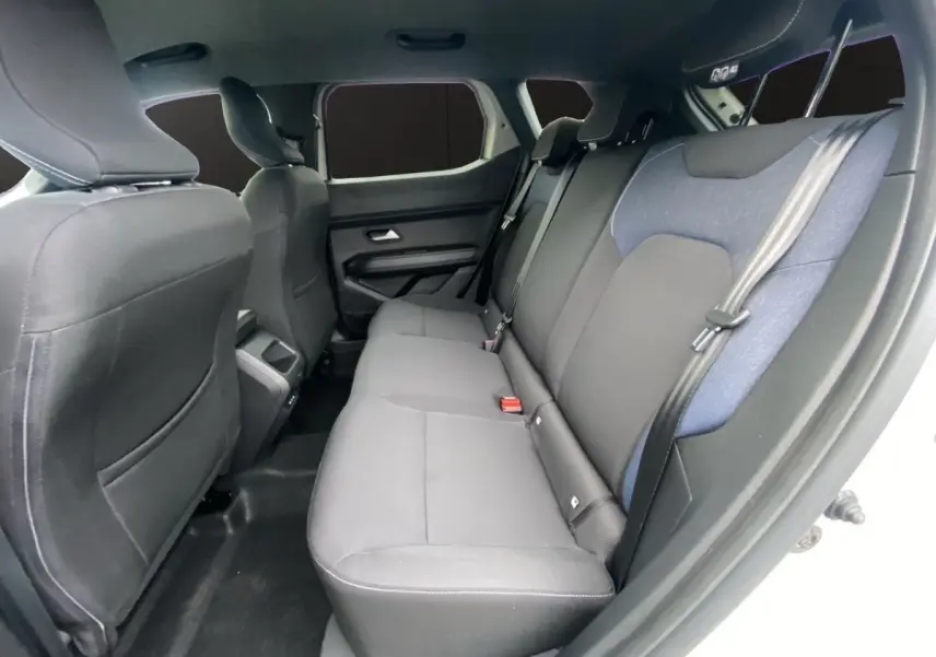 Vue intérieure côté droit sur la banquette arrière noire et grise du Dacia Duster beige, version Journey Hybrid 140.