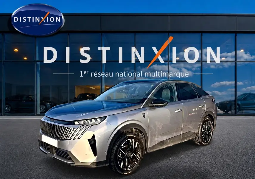 Peugeot 3008 gris en 3/4 avant droit, avec calandre distinctive et jantes alliage noires devant showroom Distinxion.