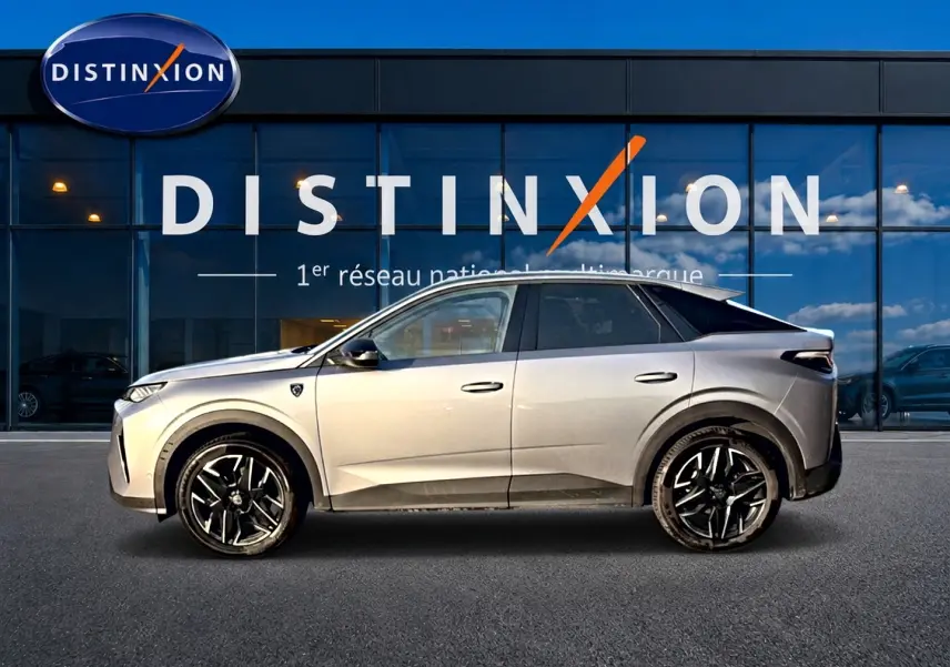 Vue de profil droit du Peugeot 3008 gris 2025 avec jantes alliage noires devant une vitrine Distinxion.