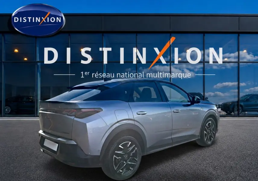 Peugeot 3008 gris en 3/4 arrière droit, avec jantes alu noires et toit noir devant une vitrine Distinxion.