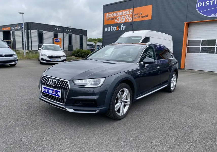 Audi A4 Allroad Quattro gris Manhattan en 3/4 avant droit, avec jantes aluminium 5 branches doubles visibles.