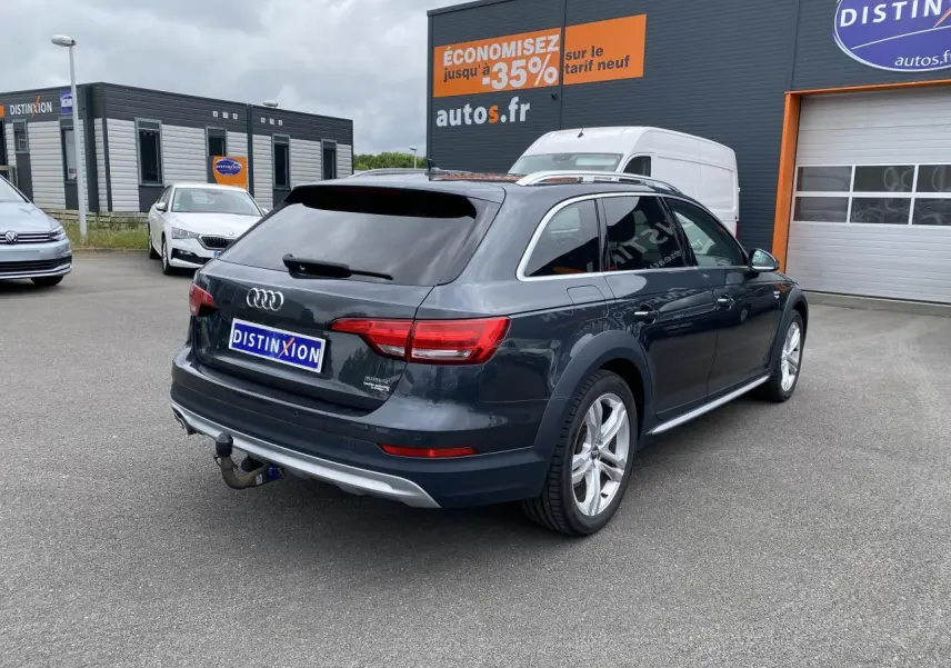 Audi A4 Allroad Quattro gris Manhattan vue 3/4 arrière droit avec crochet d'attelage et vitres surteintées.