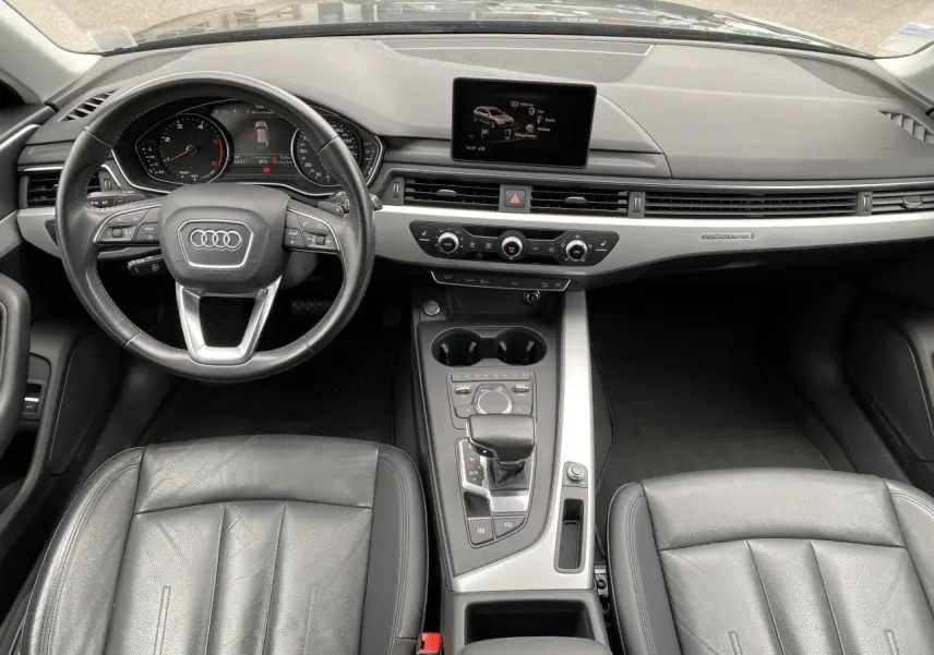 Vue intérieure avant de l'Audi A4 Allroad Quattro 2016 avec tableau de bord noir, écran central et sellerie cuir Milano noire.