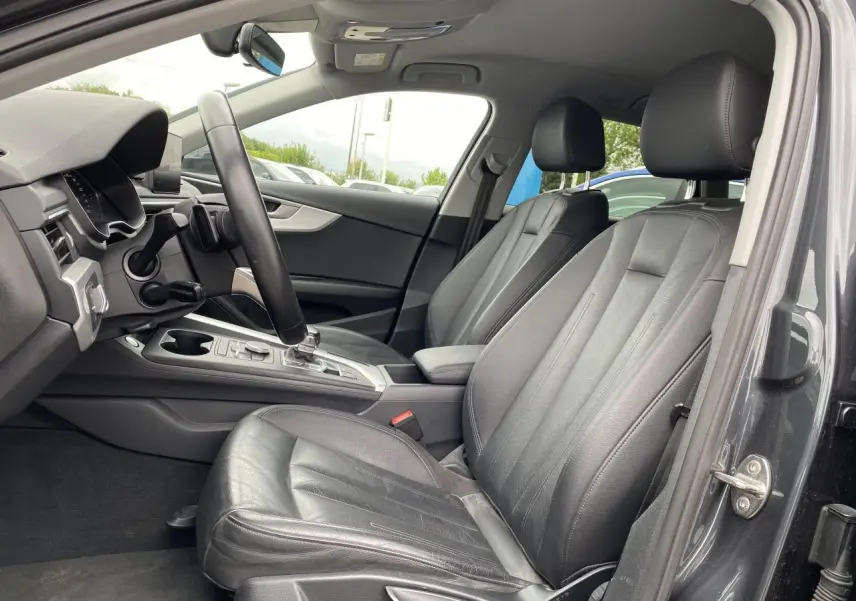 Intérieur avant droit de l'Audi A4 Allroad Quattro 2016 avec sièges cuir noirs et console centrale moderne.