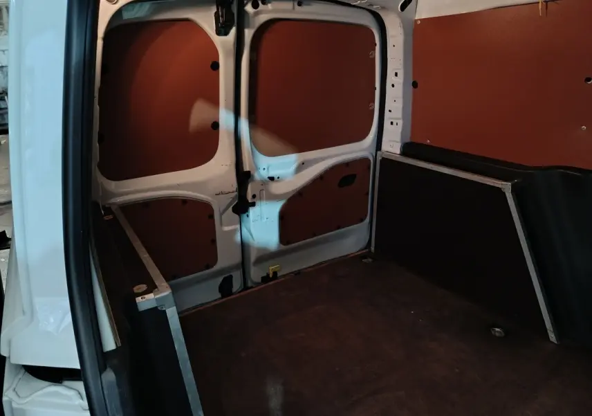 Vue intérieure arrière du Citroën Berlingo blanc 2021, montrant la cloison pleine et l'espace de chargement vide.