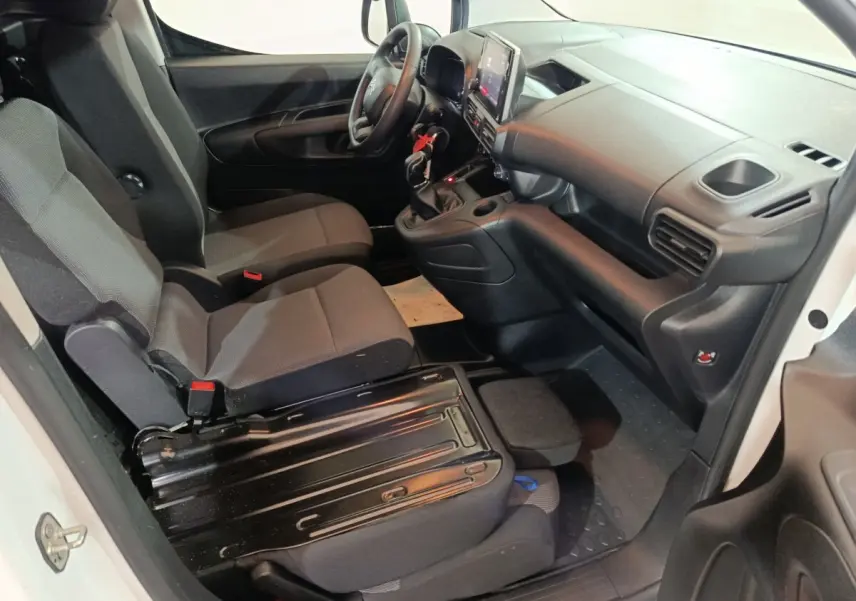 Intérieur côté conducteur du Citroën Berlingo blanc 2021, vue en plongée sur sièges et tableau de bord noir.