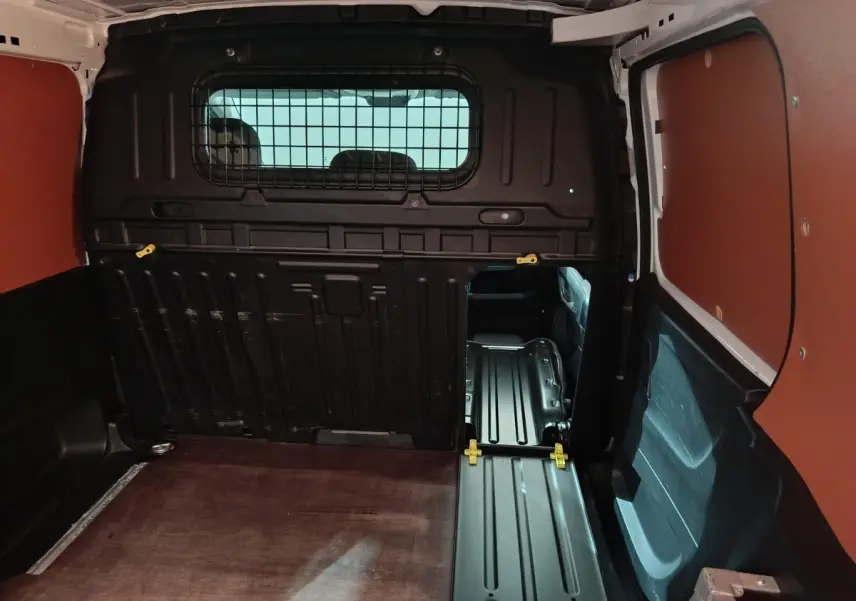 Vue intérieure du coffre du Citroën Berlingo blanc 2021, avec cloison pleine et plancher métallique visible.