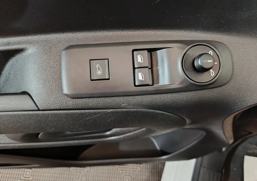 Gros plan sur les commandes de réglage des rétroviseurs et des vitres côté conducteur d’un Citroën Berlingo blanc.