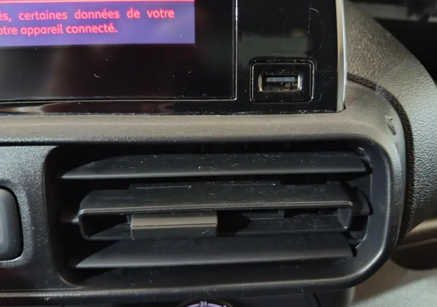 Détail de la prise USB et de la sortie d'air noire sur le tableau de bord du Citroën Berlingo blanc de 2021.