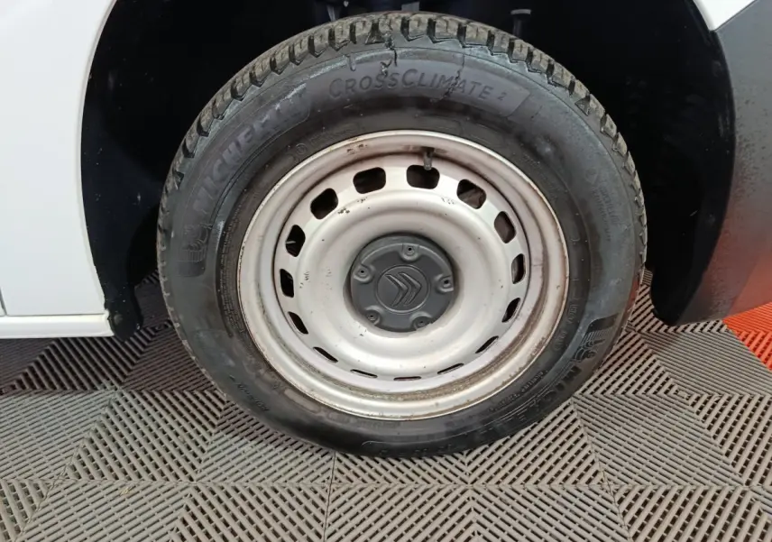 Gros plan sur la roue avant droite blanche d’un Citroën Berlingo 2021 avec jante acier et logo Citroën central.