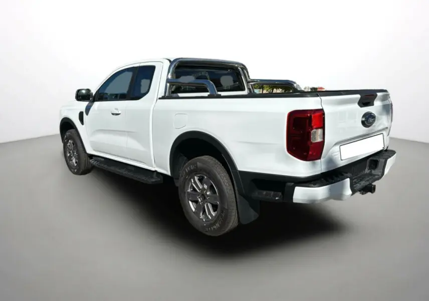 Ford Ranger blanc glacier en 3/4 arrière droit, avec arceaux inox et benne équipée d'un rideau coulissant.