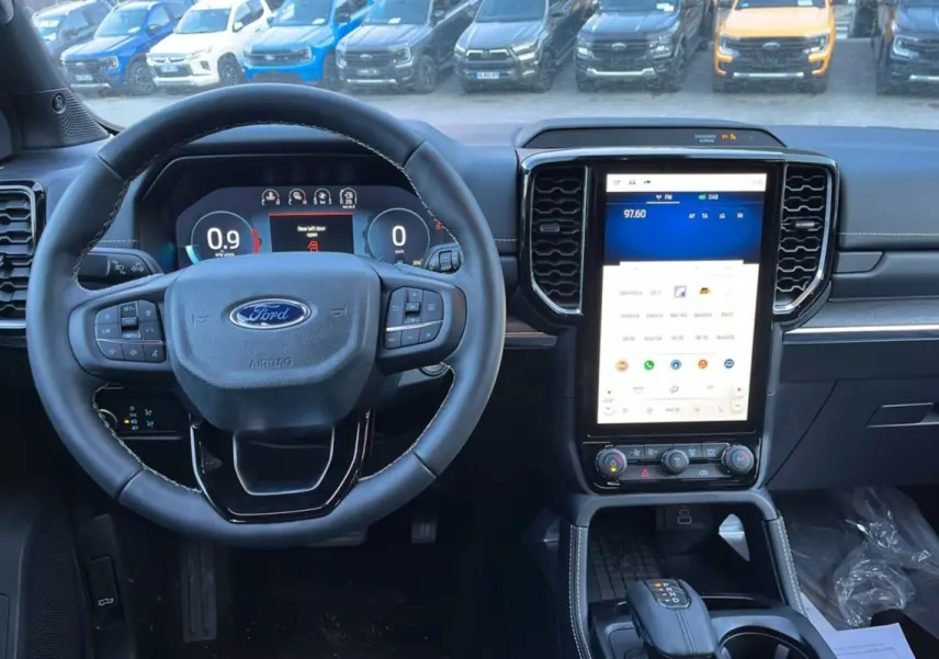 Vue intérieure centrée sur le volant cuir multifonctions et l’écran tactile vertical du Ford Ranger blanc glacier 2025.
