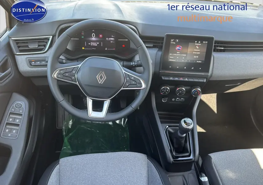 Vue intérieure avant de la Renault Clio V gris rafale, volant multifonction, écran tactile et boîte manuelle visible.