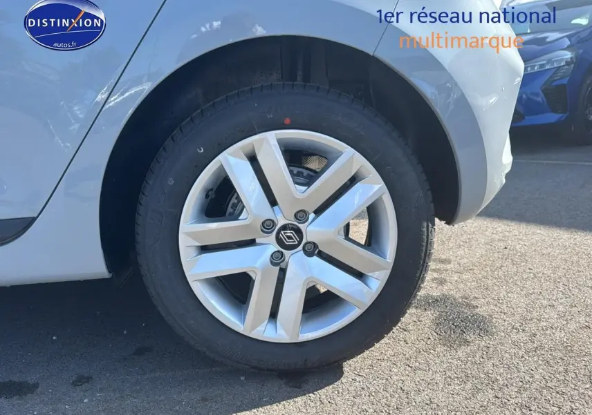 Gros plan sur la roue avant droite et la jante argentée d'une Renault Clio V gris rafale.