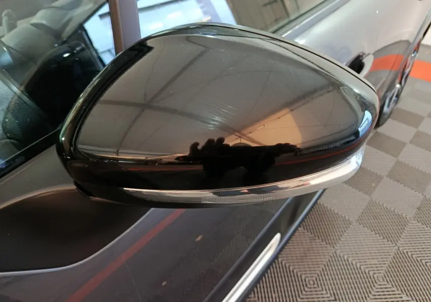 Gros plan sur le rétroviseur droit noir brillant de la Citroën C3 gris foncé, avec clignotant intégré visible.