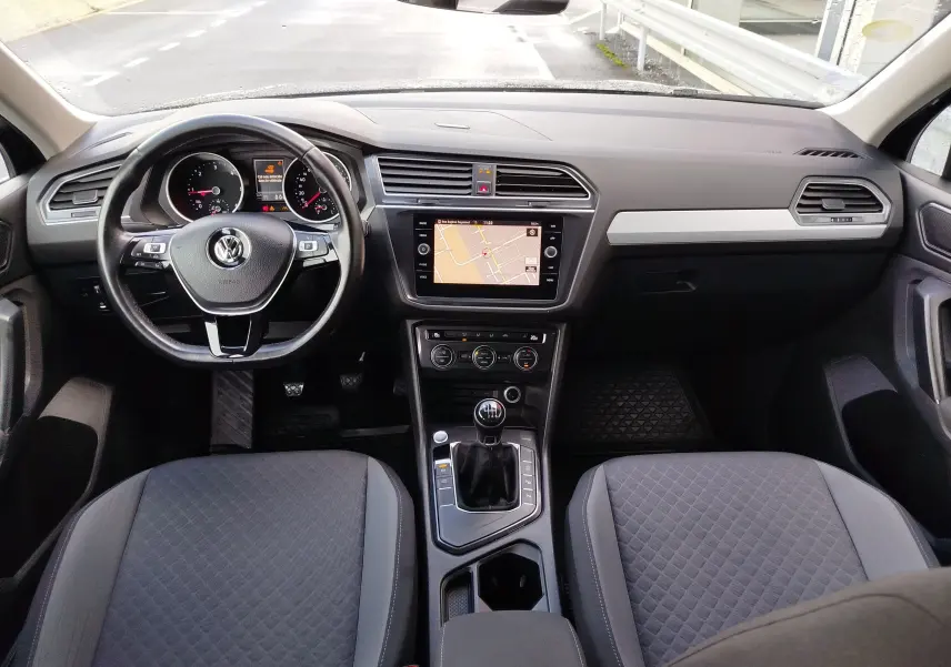 Vue intérieure frontale du Volkswagen Tiguan 2.0 TDI 2019, tableau de bord noir avec écran tactile et boîte manuelle.